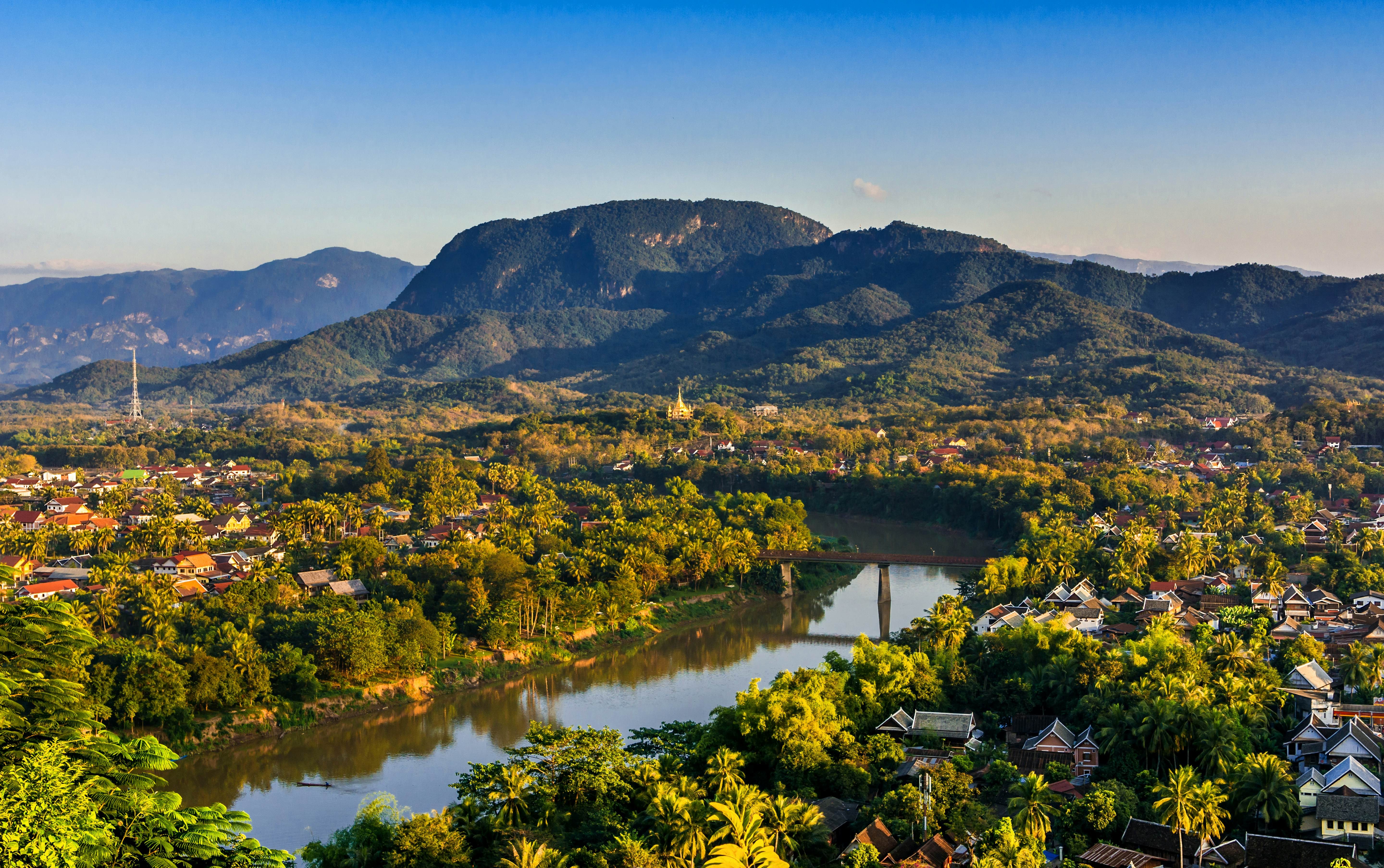 Sunset paints the sky over Luang Prabang, Laos, where the Mekong and Nam Khan rivers meet, showcasing the serene beauty of this Southeast Asian gem