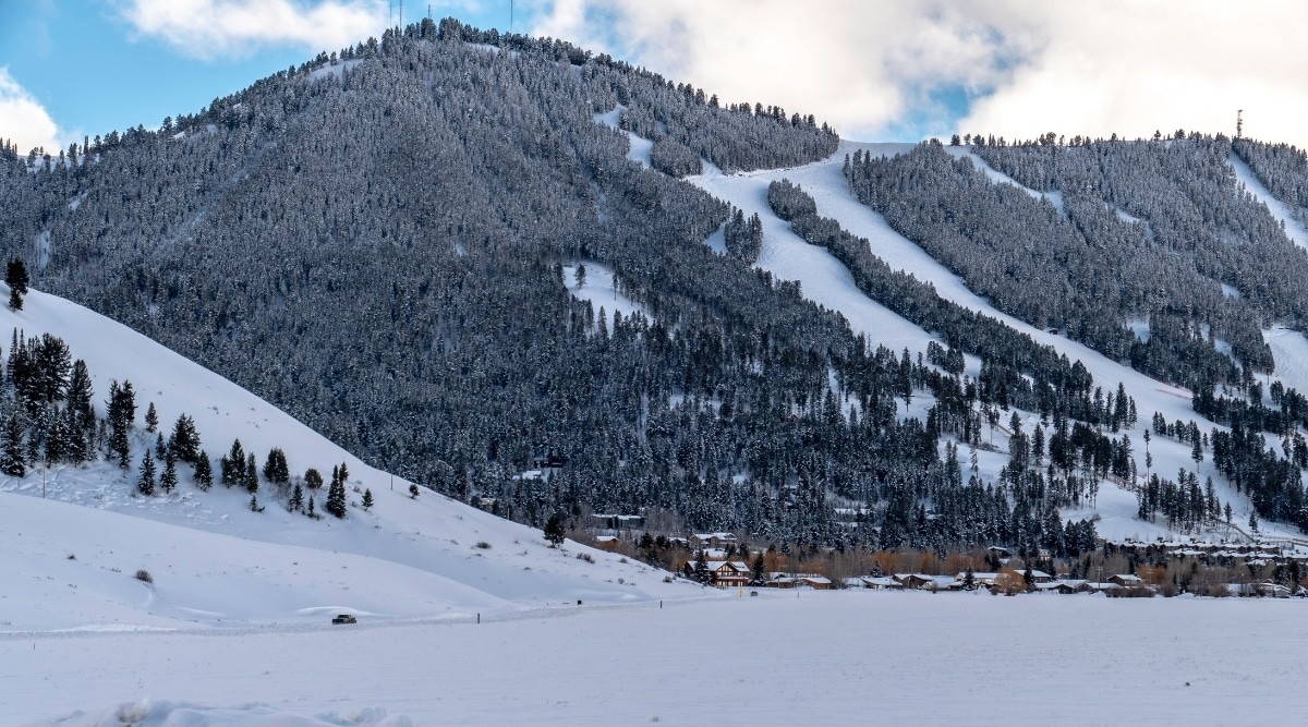 Winter view of snow-capped mountains in Jackson, Wyoming, with the cityscape nestled below.