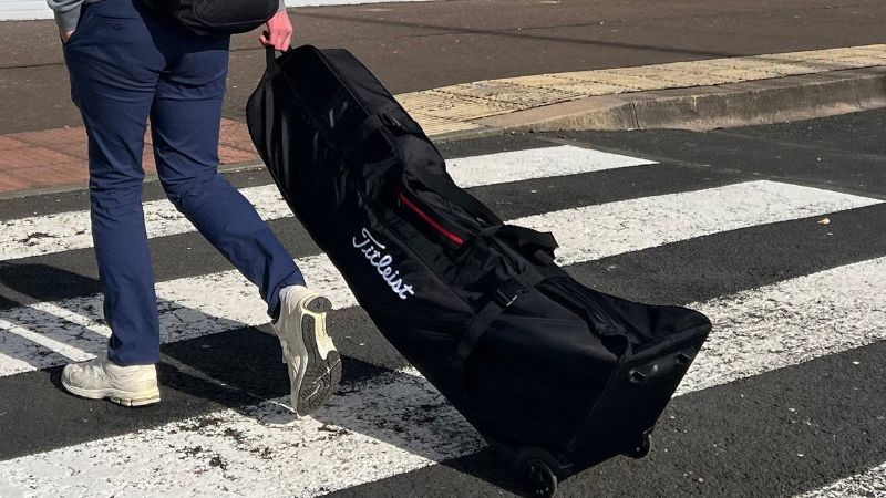 Titleist Players Travel Cover being wheeled through an airport, showcasing its robust and durable construction