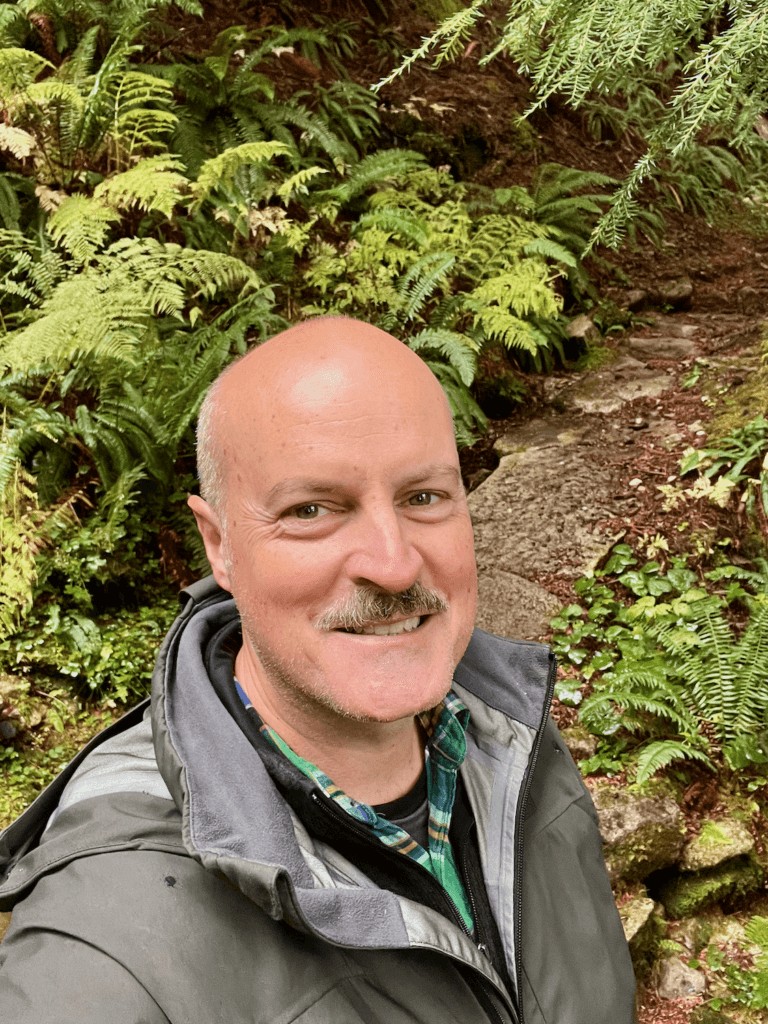 Matthew Kessi smiles during a nature connection experience at Mt. Rainier National Park, highlighting the transformative power of nature immersion in the Pacific Northwest.