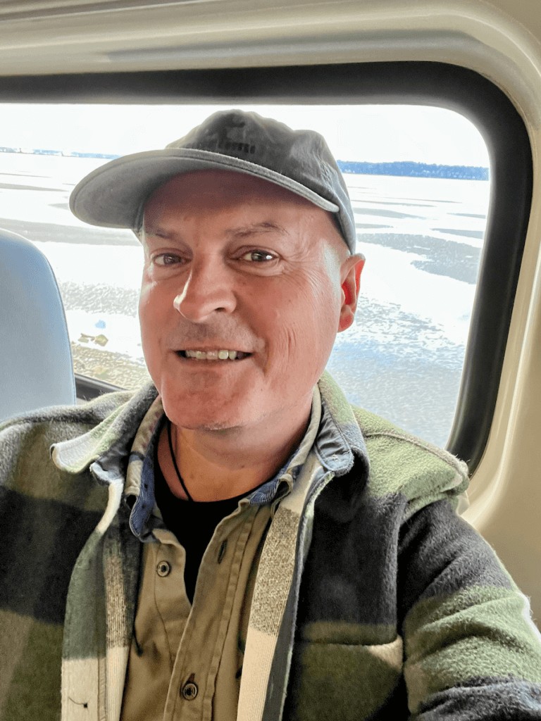 Travel expert Matthew Kessi takes a selfie on the train from Vancouver to Seattle, showcasing his nature-connected travel experience.