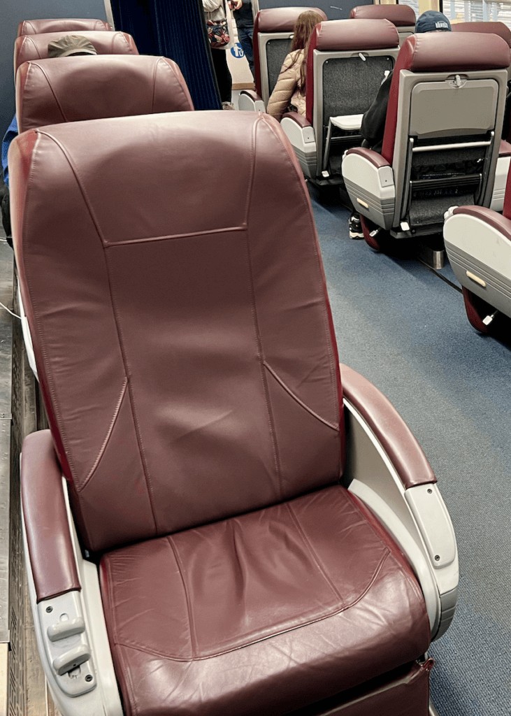 A comfortable burgundy leather seat in Amtrak Business Class, offering a premium experience on the train from Vancouver to Seattle.