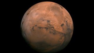 Image of Mars against the black backdrop of space. The planet is a rusty red color.