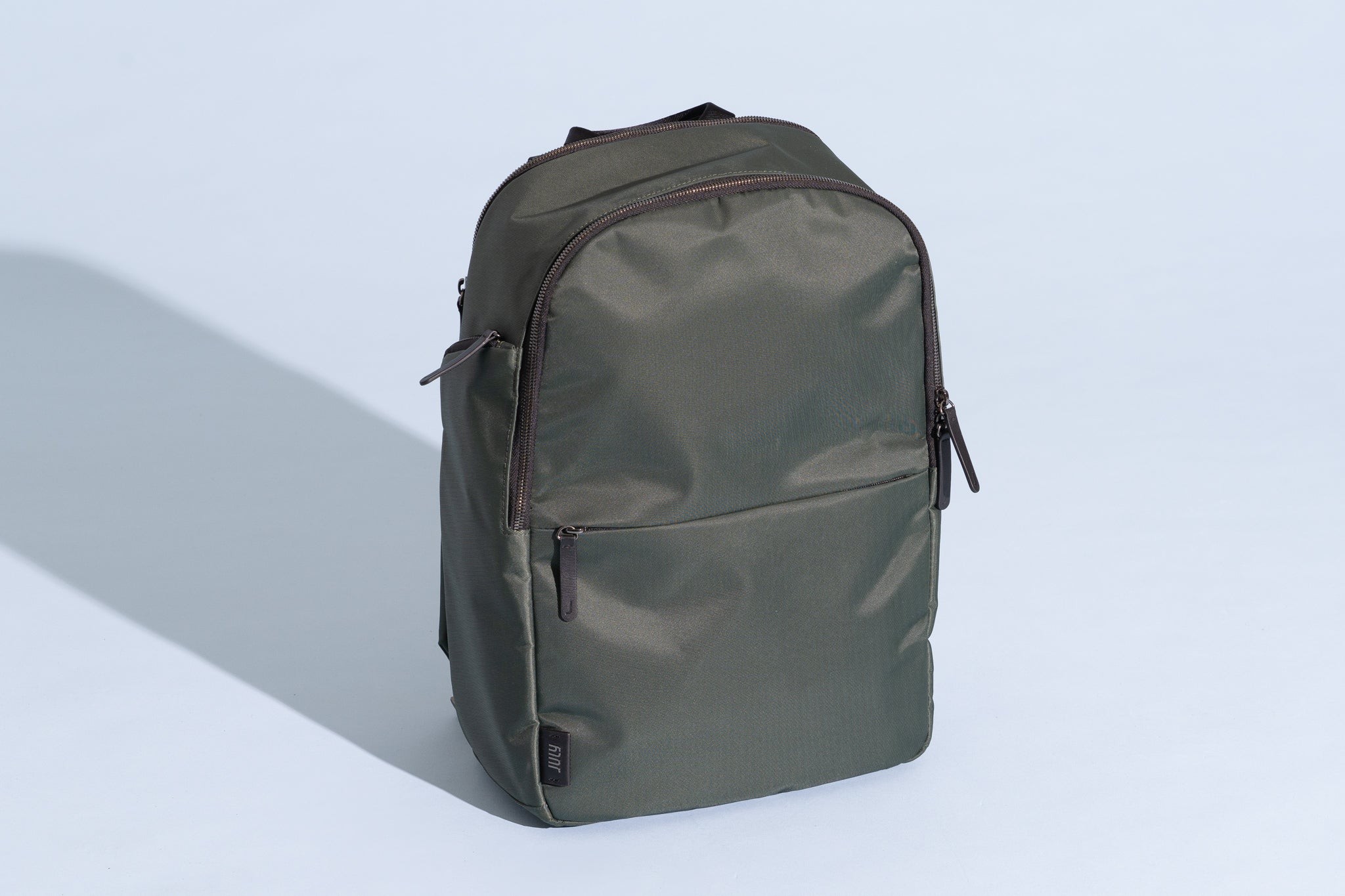 July Carry All Backpack Series 2 in a stylish gray color, highlighting its sleek design and leather accents.