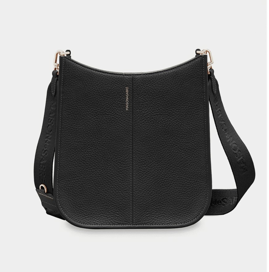 A black leather saddle bag with a long crossbody strap.