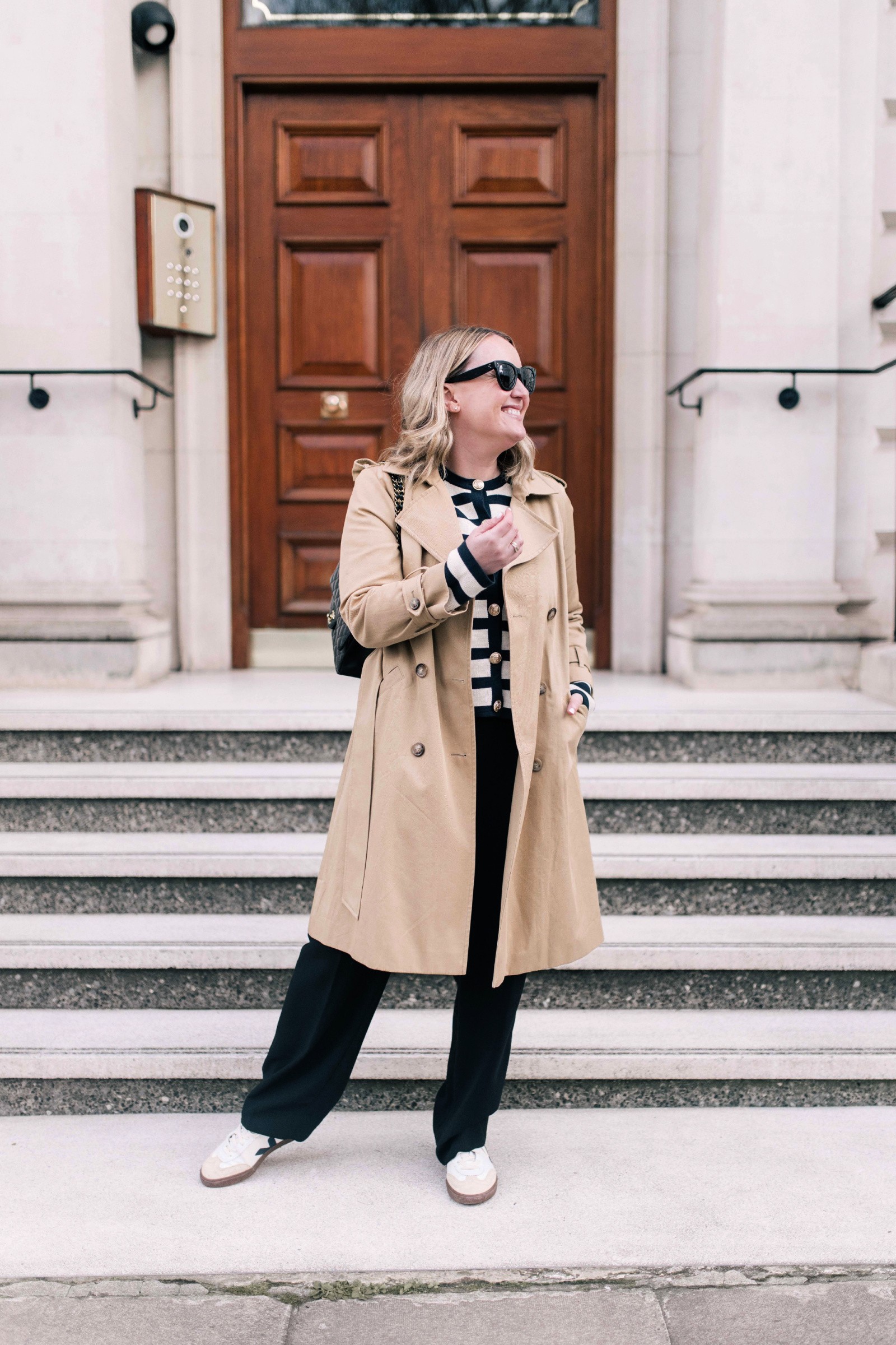 Travel outfit idea: Woman wearing a travel outfit consisting of trousers and a knit jacket, perfect for long flights and stylish airport looks.