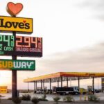 Photograph of a Love's Travel Stop exterior, highlighting its clean and modern design, with fuel pumps visible and the Love's logo prominently displayed.