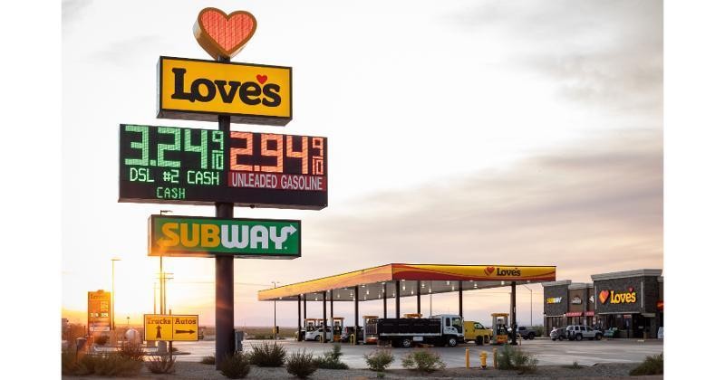 Photograph of a Love's Travel Stop exterior, highlighting its clean and modern design, with fuel pumps visible and the Love's logo prominently displayed.