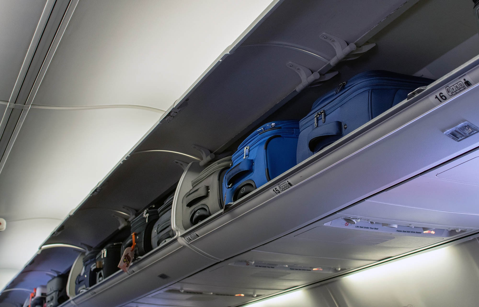 Carry-on luggage in overhead bins on an airplane