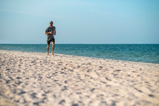 A person enjoying the radiant Caribbean sunshine while jogging along the beach