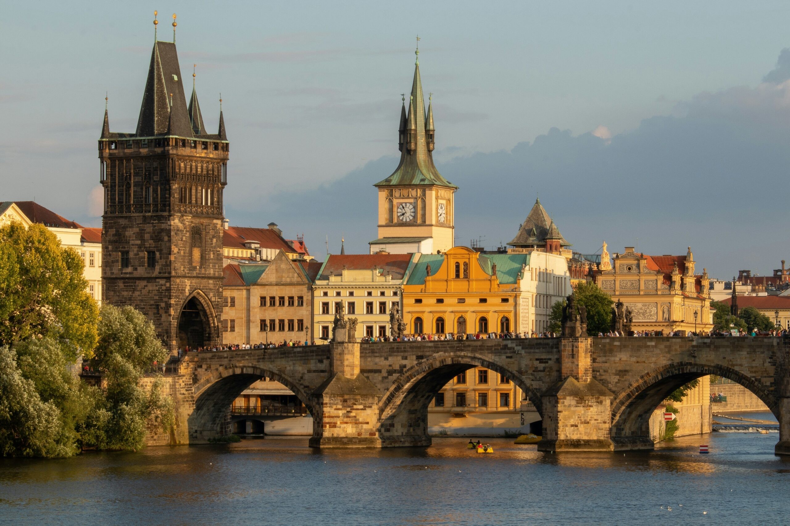 Iconic Charles Bridge in Prague at dusk, reflecting city lights, representing a historical and romantic European city break