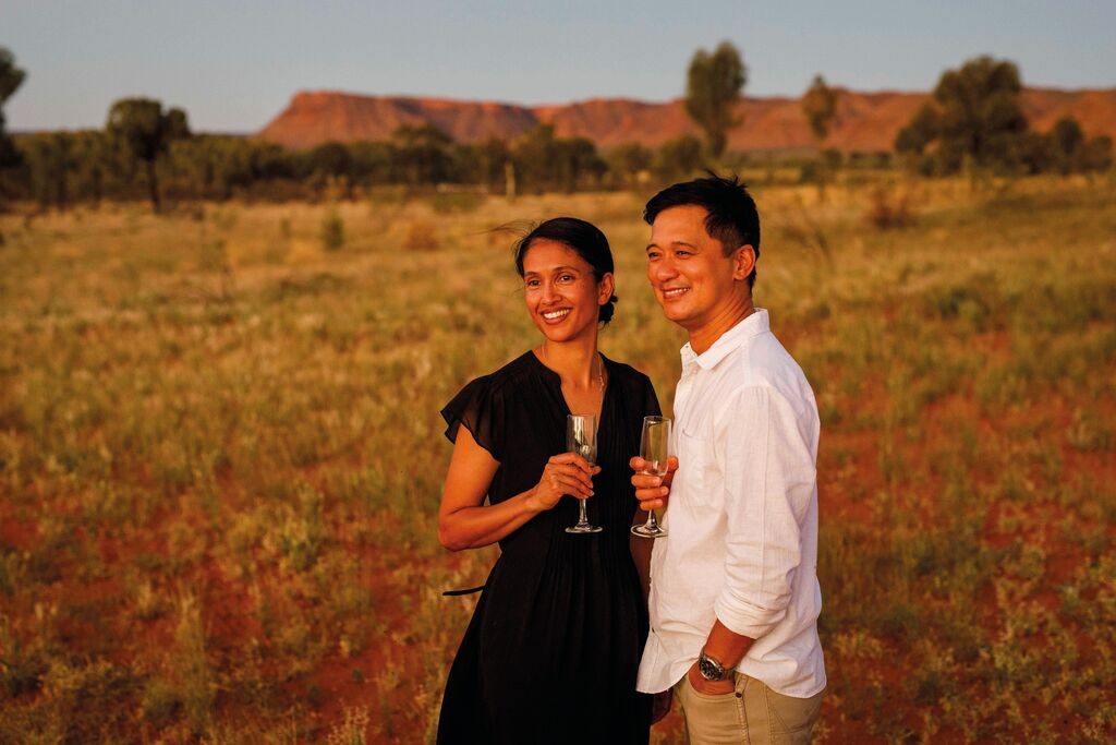 Couple watching sunset at Kings Canyon, Australia, capturing the vastness and vibrant colors of the Outback for an adventurous anniversary