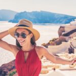 Woman standing on a mountain top looking at a view, representing the joy of travel and exploration