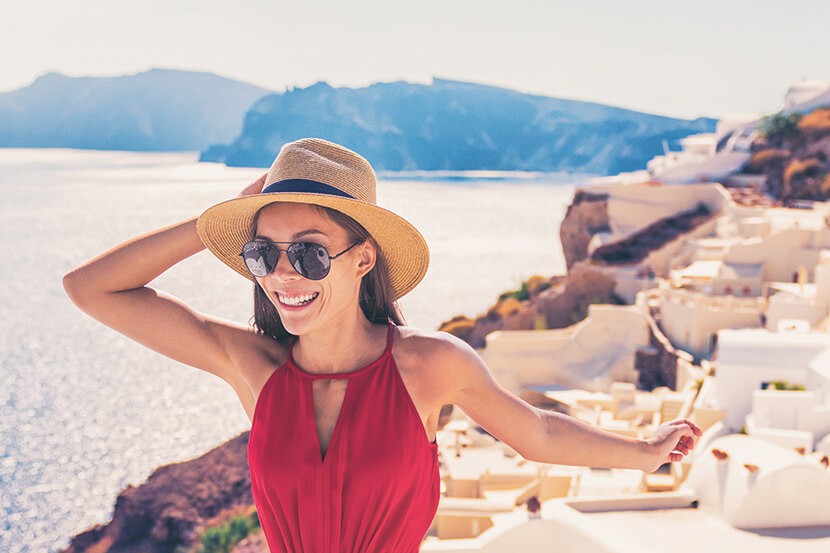 Woman standing on a mountain top looking at a view, representing the joy of travel and exploration