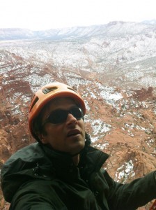 Climber wearing REI Edgewood Travel Coat ascending near the summit of Titan in Fisher Towers