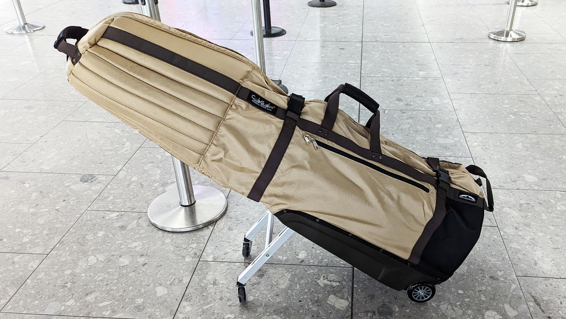 Sun Mountain Club Glider Meridian Travel Cover in use at an airport, demonstrating its smooth rolling capability