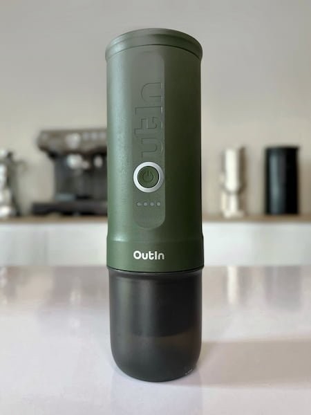 Outin Nano portable espresso maker with a blurred background