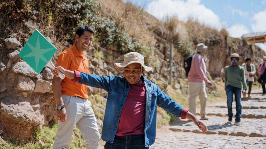 A child on an Adventures by Disney tour smiles holding a paddle in Peru