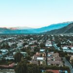 Aerial view of Palm Springs, California, at dawn, showcasing the city's desert landscape and architecture under a clear sky.