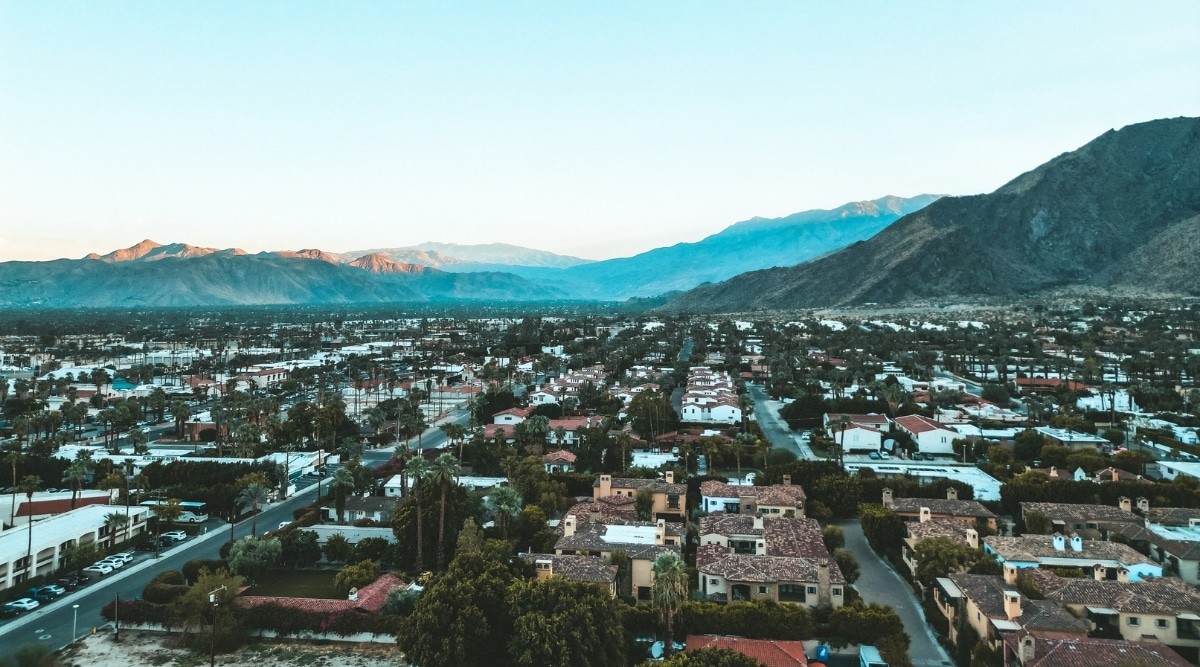 Aerial view of Palm Springs, California, at dawn, showcasing the city's desert landscape and architecture under a clear sky.