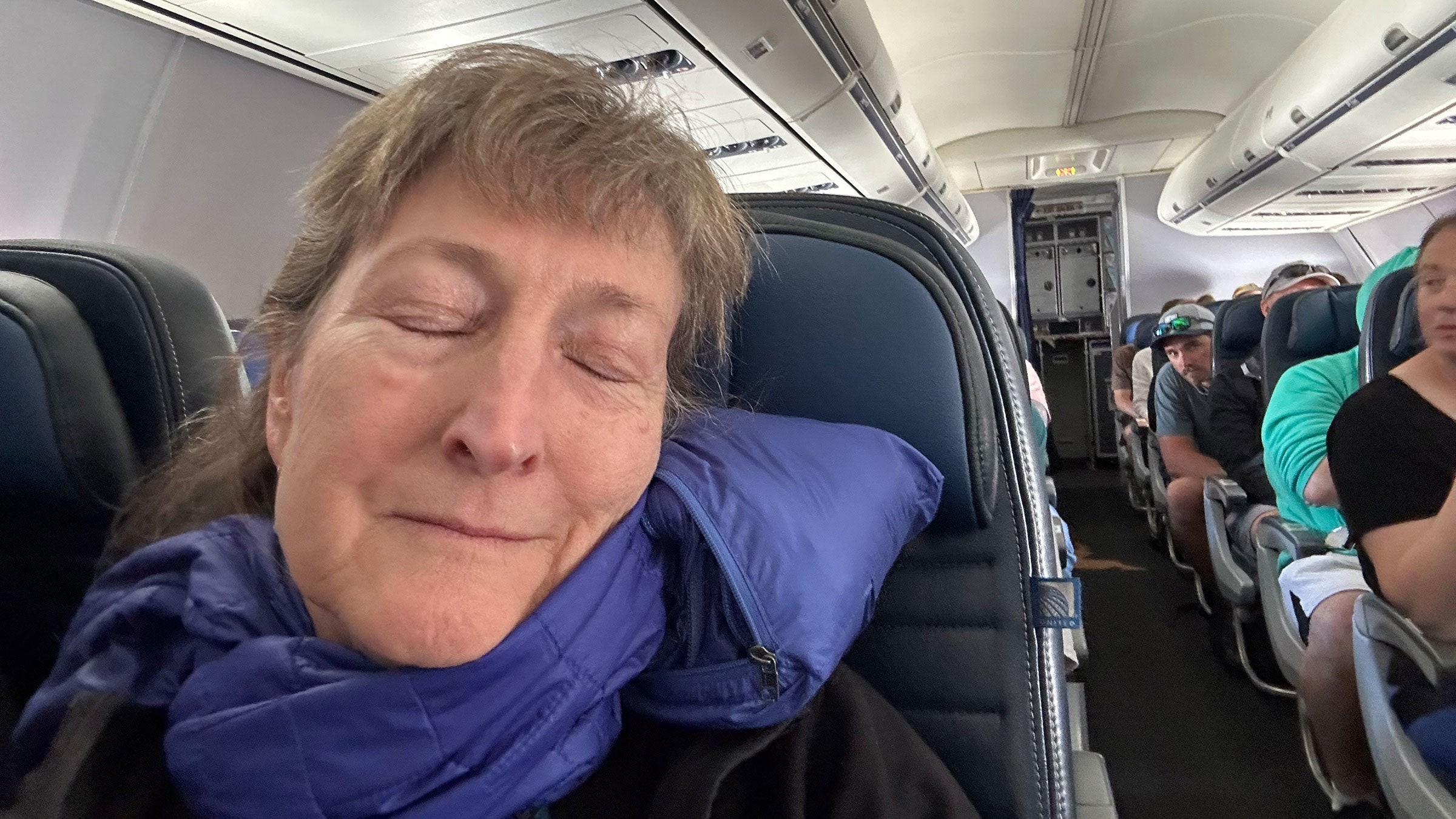 woman sleeping with Patagonia puffy jacket on airplane