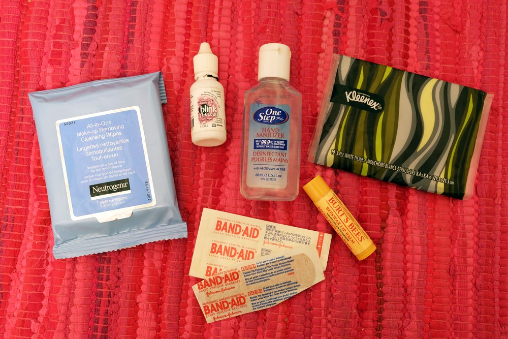 A woman's purse with essential travel items peeking out, suggesting items like hand sanitizer and tissues.