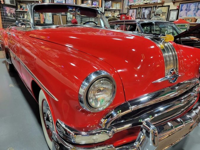 A shiny red vintage convertible car on display at the museum