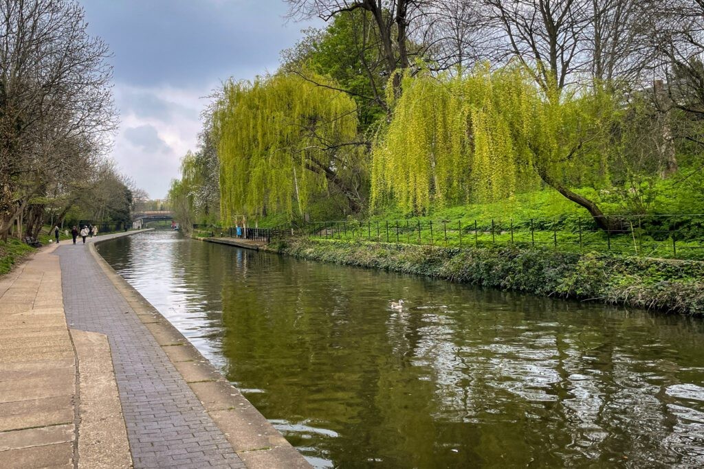 Regent's Canal in London, with narrowboats moored along the towpath and trees lining the canal banks