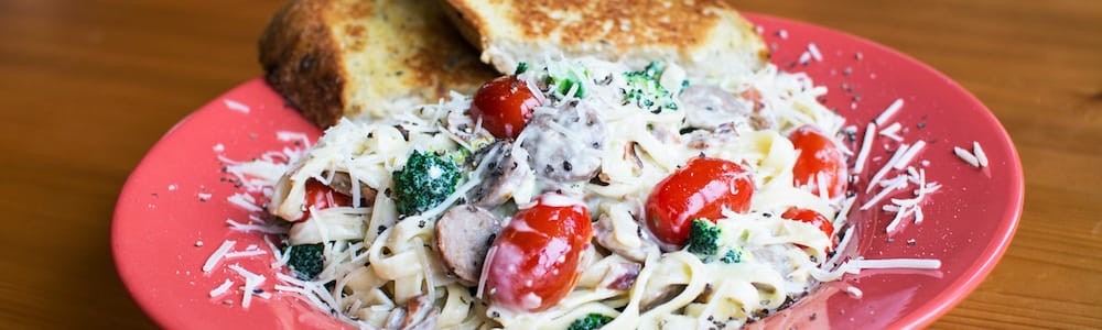 An enticing close-up of pasta with seafood and vegetables, showcasing the fresh ingredients and vibrant colors of the dish.