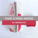 A peek inside a handmade travel sewing kit, showcasing essential sewing tools like scissors, thread, needles, and a ruler