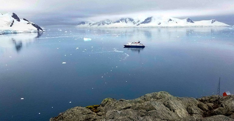 A ship rests in the calm waters of Paradise Bay, Antarctica, near the Argentine Base Brown research station.