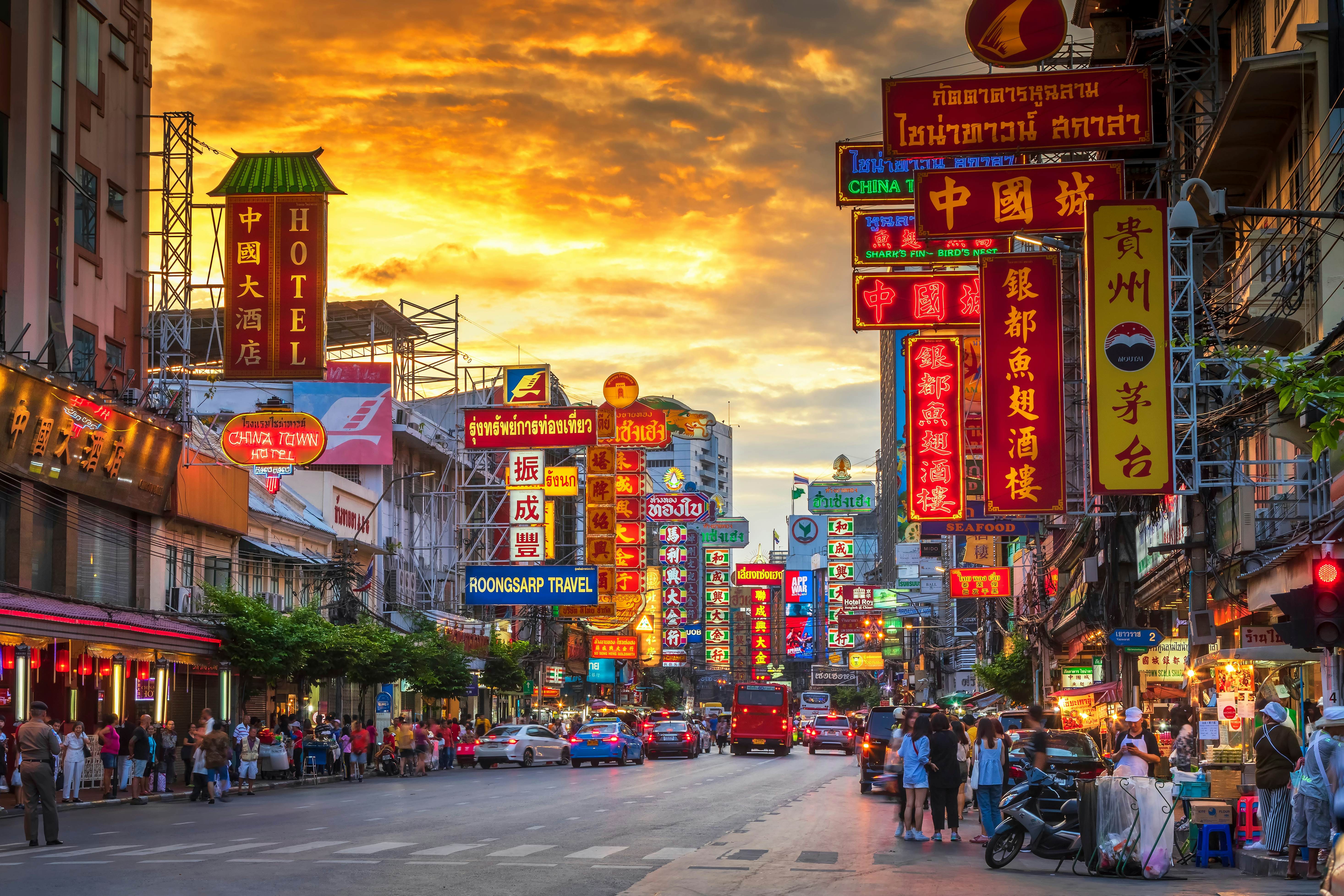 Neon signs illuminate the vibrant street food stalls of Bangkok's Chinatown, a culinary paradise in the heart of Thailand