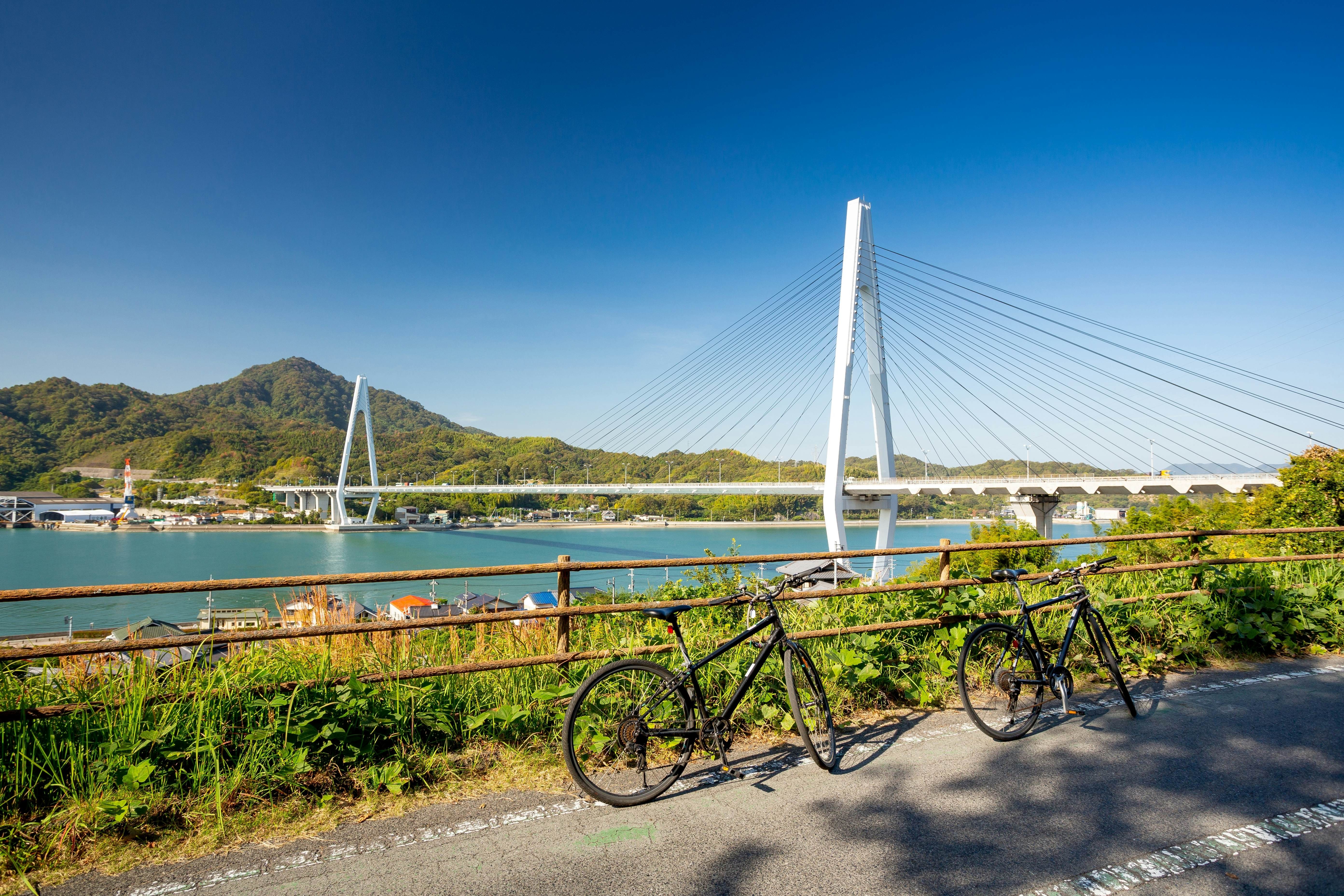 Setouchi, Japan, with bicycles leaning against railings on a bridge, part of the Shimanami Kaido cycling route linking islands in the Inland Sea