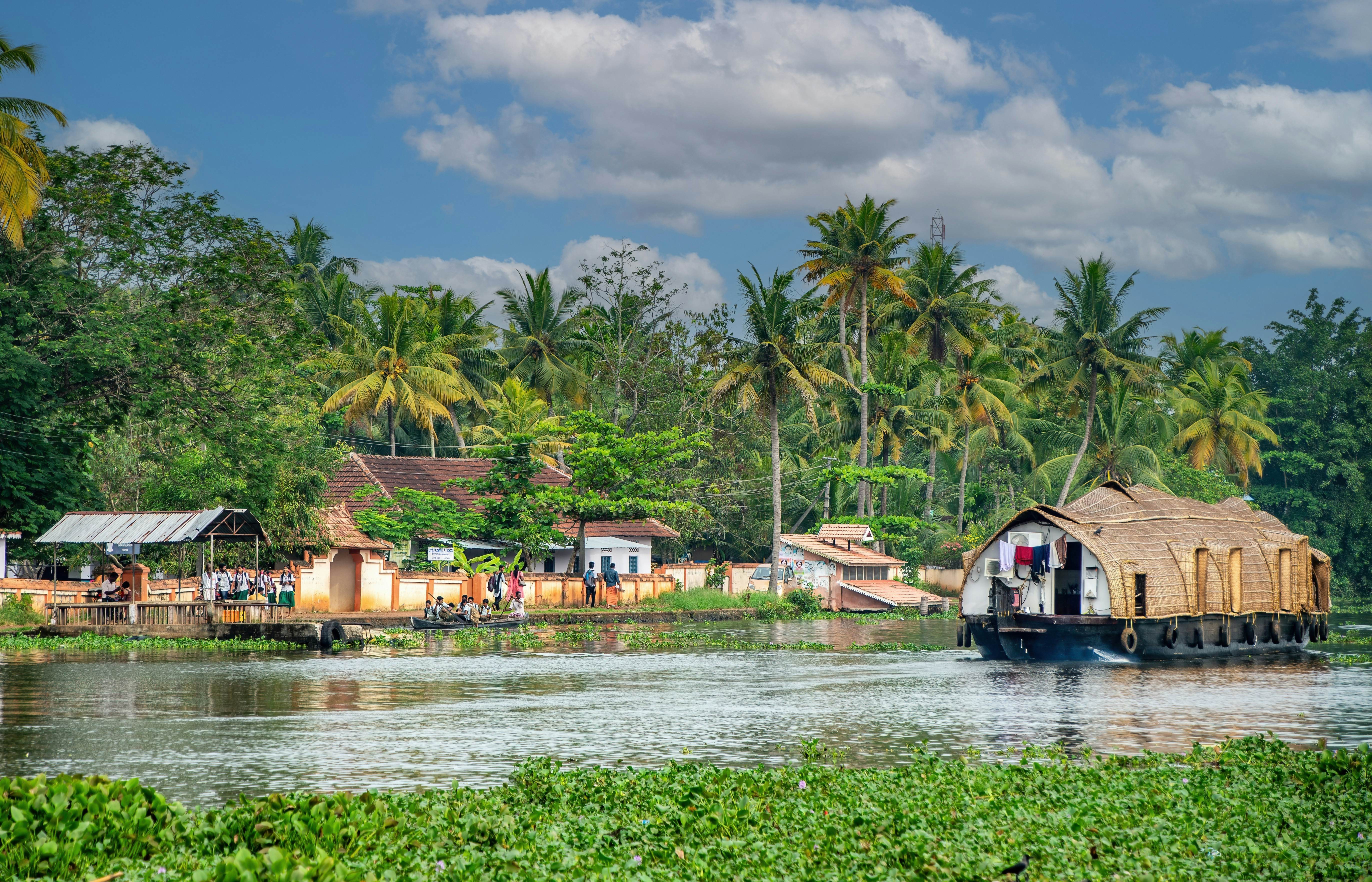 Kerala backwaters in India, with lush tropical scenery and houseboats cruising through serene waterways