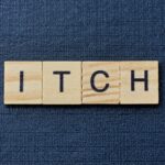 Scrabble tiles reading Itch against a dark blue background - Zap It mosquito bite zapper review for effective itch relief