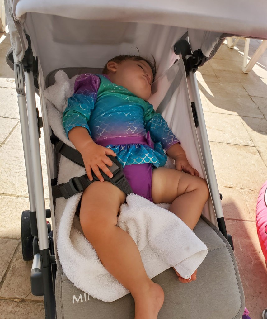 baby wearing bathing suit asleep in uppababy minu stroller