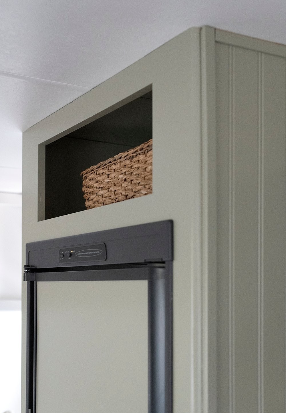 Basket above camper fridge used as snack storage