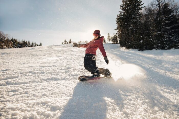 Snowboarder carving down a slope at Snowshoe Mountain Resort