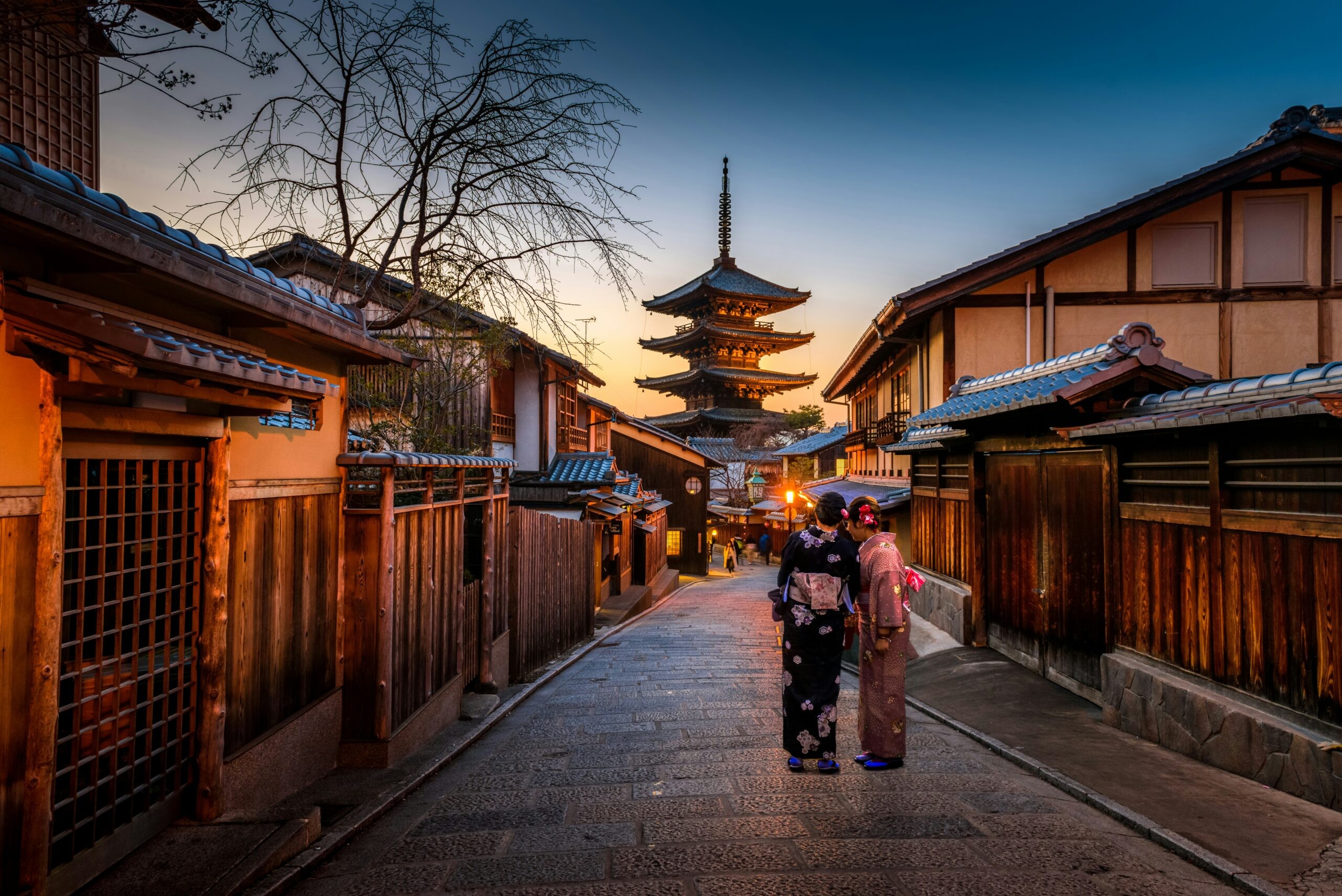 Serene sunset view of Kyoto, Japan, with traditional architecture, suggesting cultural richness and tranquility for an anniversary trip