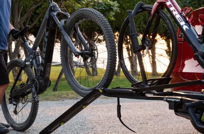 Loading a bike onto a rack using a Swagman bike ramp, showcasing ease of use.