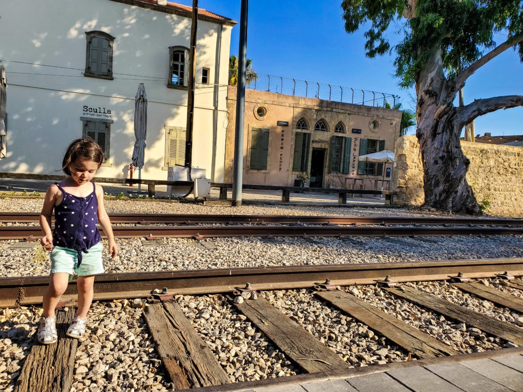 girl standing on railroad tracks in old train station tel aviv