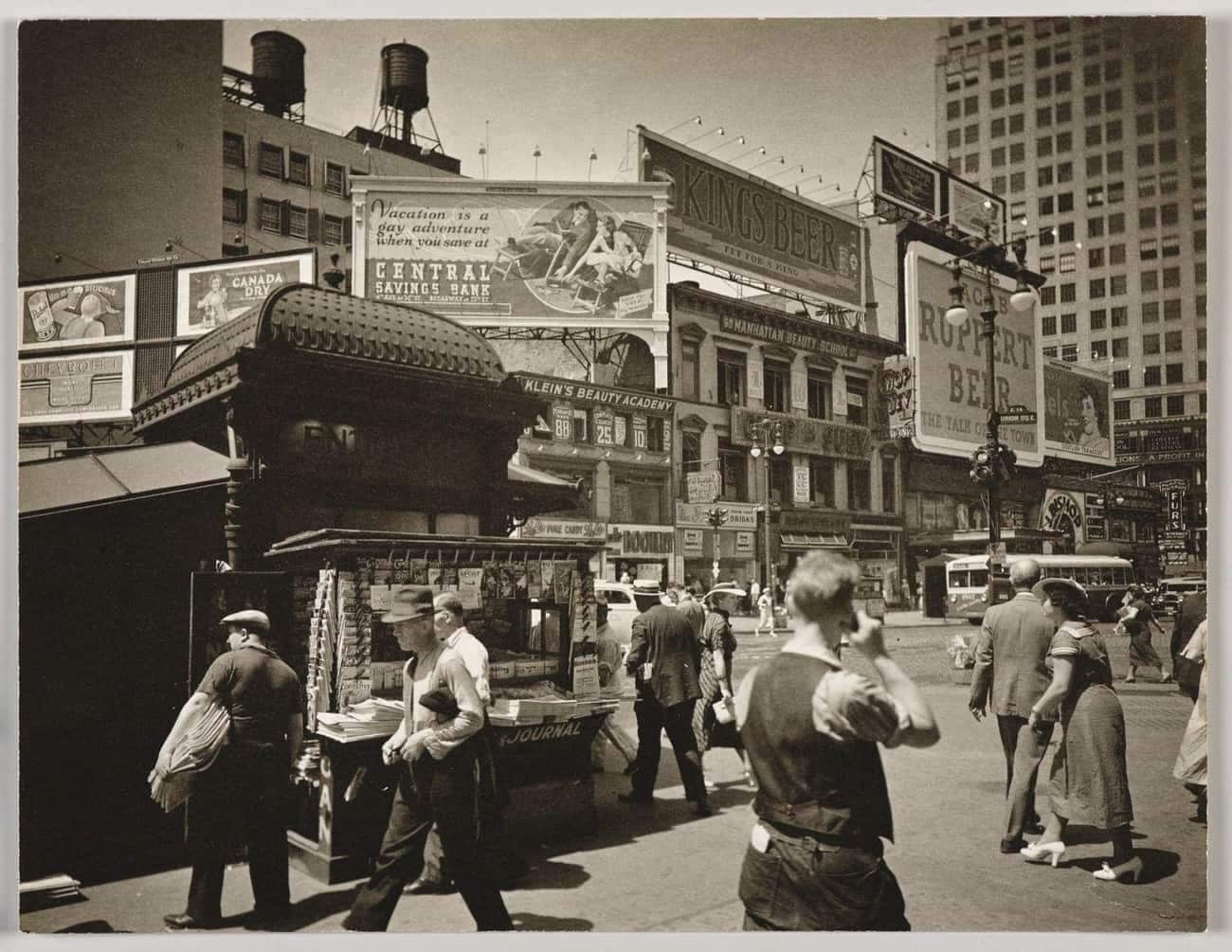 A blurry vintage photo depicting a man holding a device to his ear that resembles a cell phone, in a setting that appears to predate mobile technology.