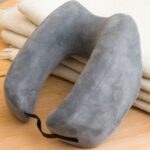 Travelrest Ultimate memory foam neck pillow in donut shape, resting on a blanket, Wirecutter's top pick for travel pillows.