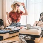 Girl packing suitcase for travel booked on best travel booking websites. Planning a staycation or vacation with online travel agencies.