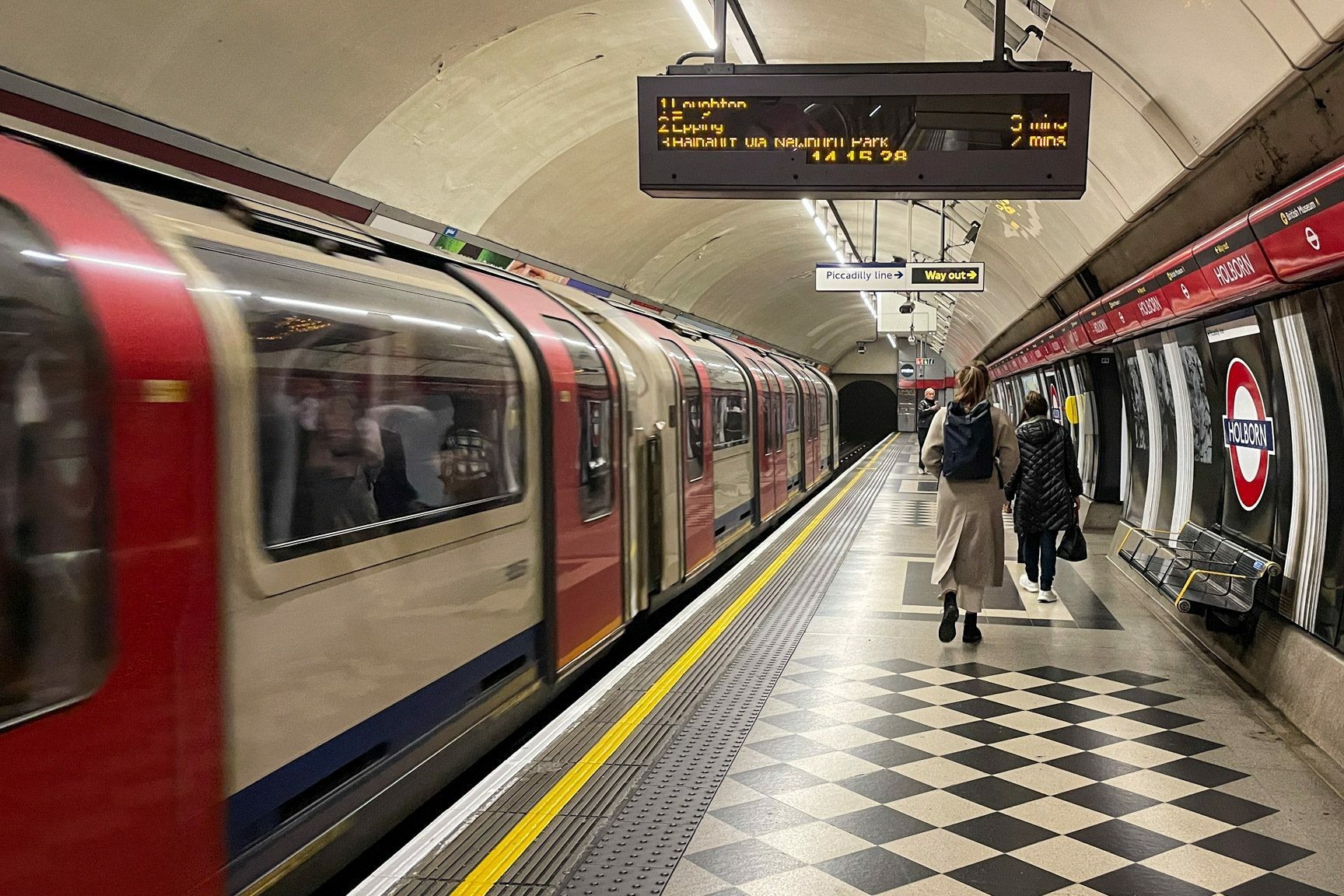 A brightly lit Tube Station sign in London, showcasing the iconic Underground logo