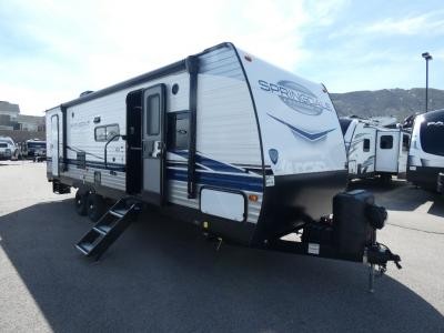 A spacious bunkhouse area in a used family travel trailer, showing multiple beds.