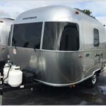 Exterior view of a compact Airstream Bambi travel trailer, showcasing its sleek design and manageable size.