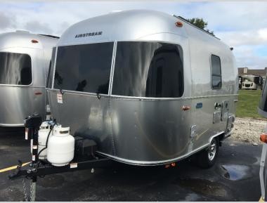 Exterior view of a compact Airstream Bambi travel trailer, showcasing its sleek design and manageable size.