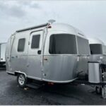 Exterior view of a compact Airstream Bambi travel trailer showcasing its classic design and small footprint.