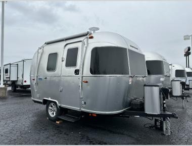 Exterior view of a compact Airstream Bambi travel trailer showcasing its classic design and small footprint.